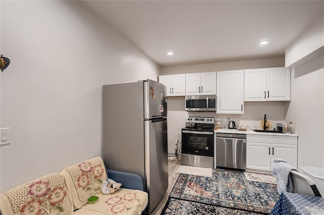 kitchen with appliances with stainless steel finishes, sink, and white cabinets