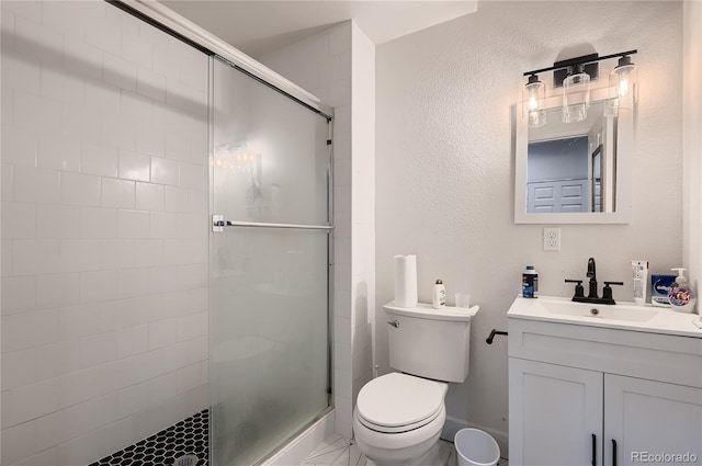 bathroom featuring vanity, a shower with door, and toilet