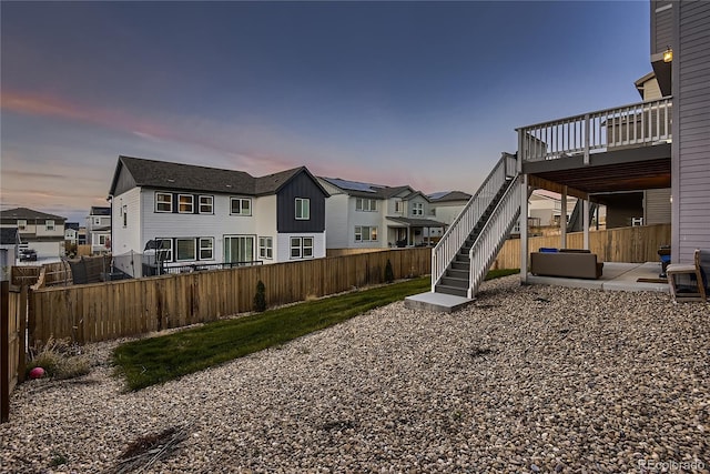 yard at dusk featuring a patio and a deck