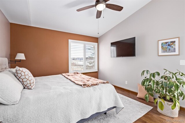 bedroom with wood finished floors, ceiling fan, and lofted ceiling