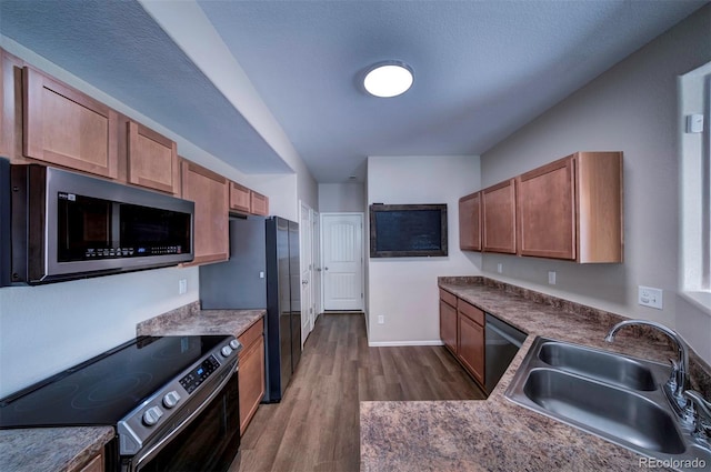 5336 Blair Vw, Colorado Springs, CO 80916 - kitchen with stainless steel appliances, a sink, baseboards, brown cabinets, and dark wood finished floors