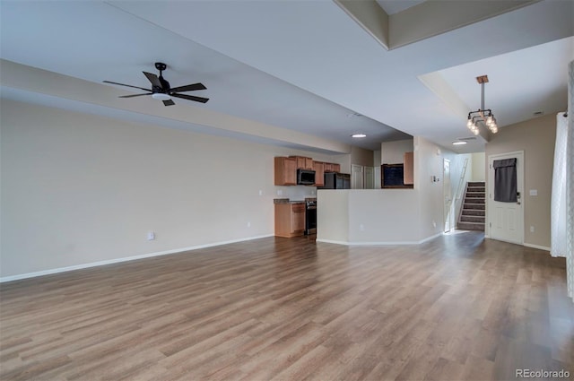 5336 Blair Vw, Colorado Springs, CO 80916 - unfurnished living room featuring ceiling fan, stairway, baseboards, and light wood finished floors