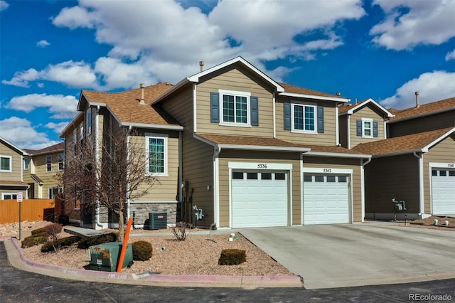 5336 Blair Vw, Colorado Springs, CO 80916 - view of front of home featuring driveway, a shingled roof, stone siding, an attached garage, and cooling unit
