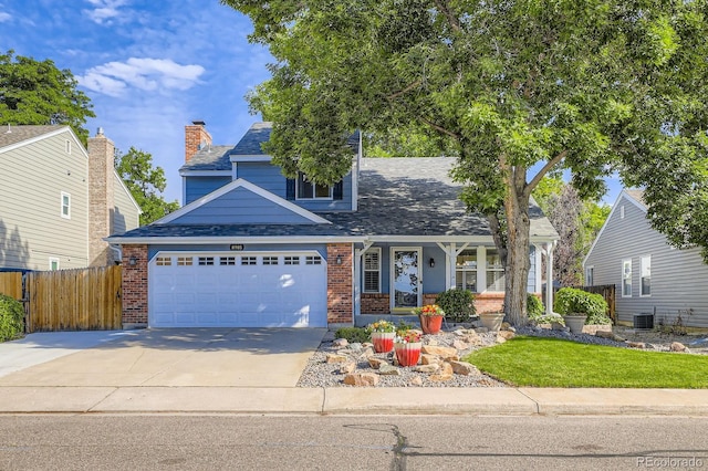 8985 W Quarto Pl, Littleton, CO 80128 - view of front of home with a porch, driveway, brick siding, and roof with shingles