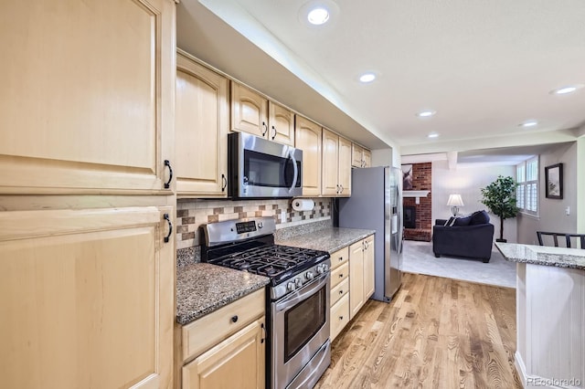 8985 W Quarto Pl, Littleton, CO 80128 - kitchen with appliances with stainless steel finishes, light brown cabinets, light wood finished floors, light stone countertops, and recessed lighting