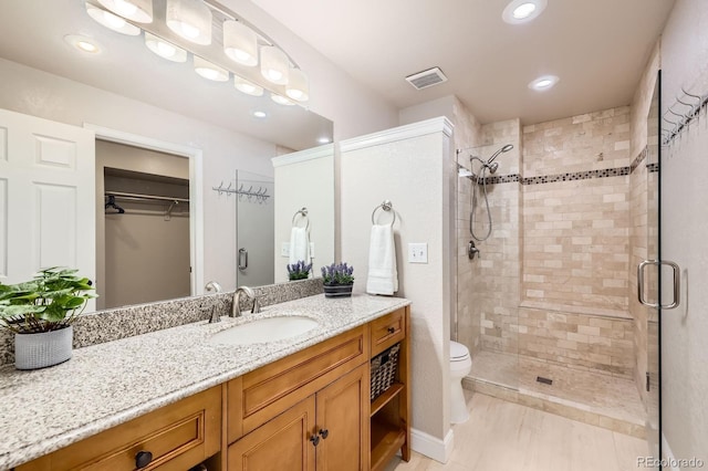 8985 W Quarto Pl, Littleton, CO 80128 - bathroom with a stall shower, vanity, a spacious closet, and recessed lighting