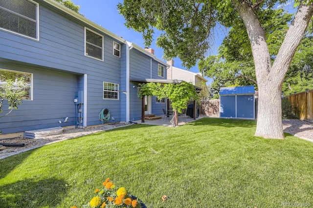 8985 W Quarto Pl, Littleton, CO 80128 - fenced backyard featuring a patio and a storage unit