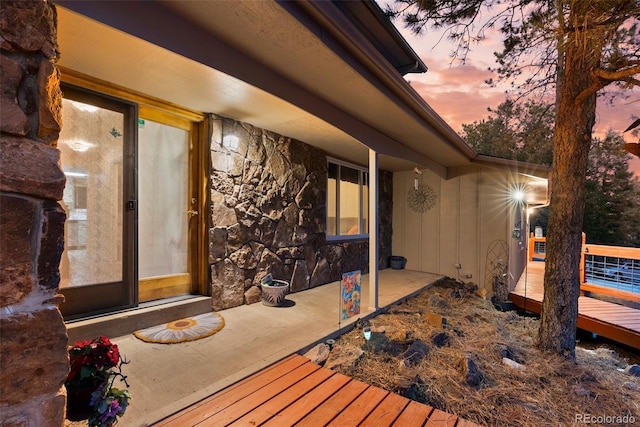 exterior entry at dusk with a wooden deck