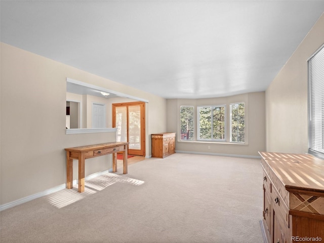 unfurnished living room with light colored carpet