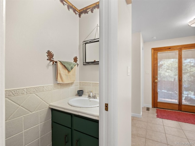 bathroom with tile patterned flooring, vanity, and tile walls