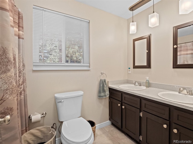 bathroom with toilet, vanity, and tile patterned floors