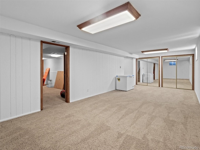 basement with refrigerator and light colored carpet