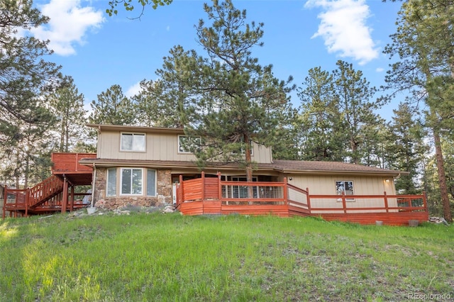 28735 Little Big Horn Dr, Evergreen, CO 80439 - back of property with a wooden deck, stone siding, and stairway