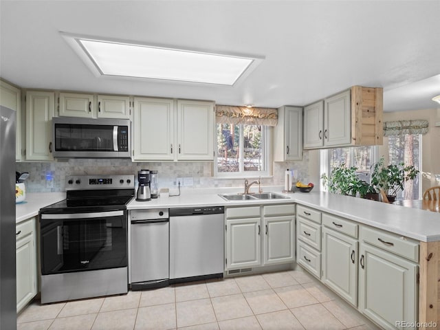 28735 Little Big Horn Dr, Evergreen, CO 80439 - kitchen featuring appliances with stainless steel finishes, a sink, a peninsula, and light countertops