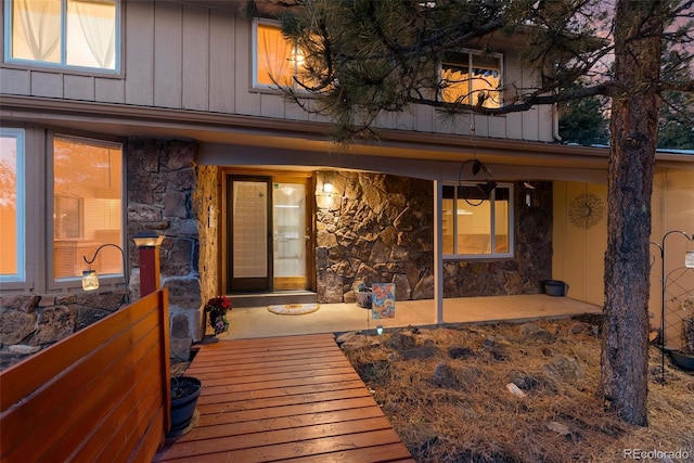 28735 Little Big Horn Dr, Evergreen, CO 80439 - doorway to property with stone siding and board and batten siding