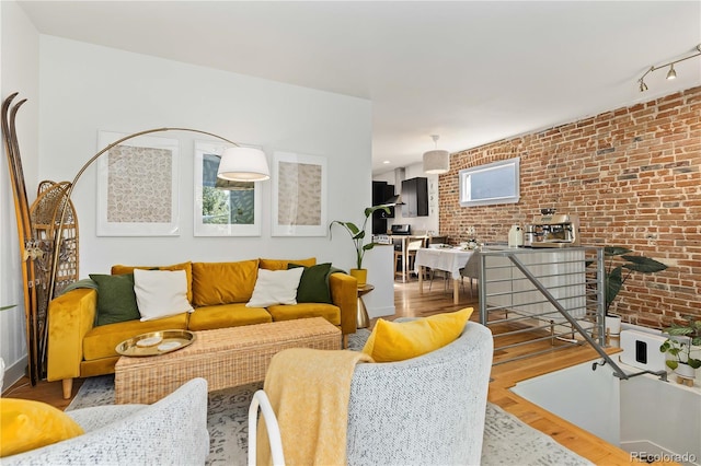 living room featuring brick wall and light wood-type flooring