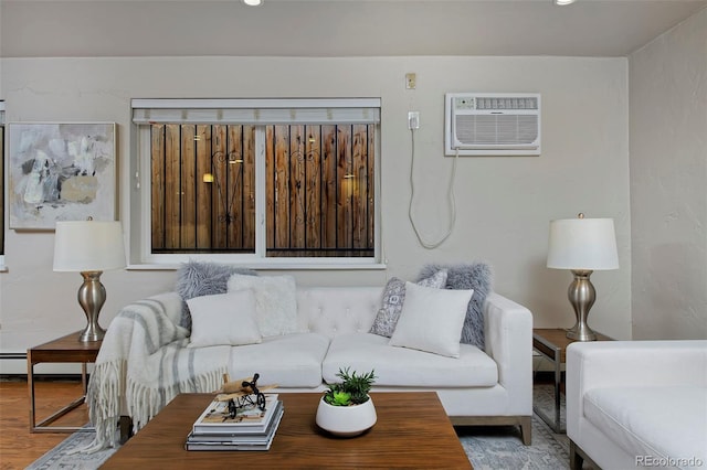 living room featuring wood-type flooring, a baseboard heating unit, and a wall mounted air conditioner