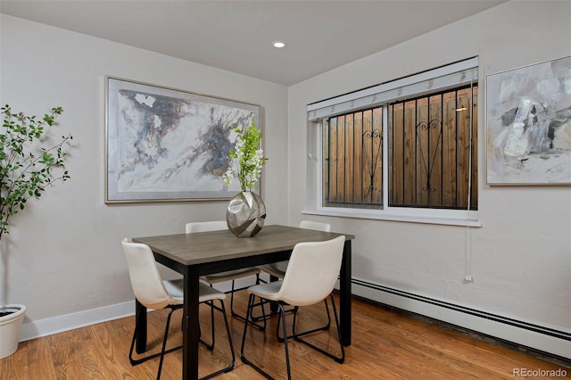 dining space featuring hardwood / wood-style floors and baseboard heating