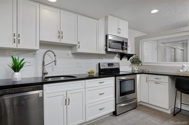 kitchen with appliances with stainless steel finishes, sink, and white cabinets