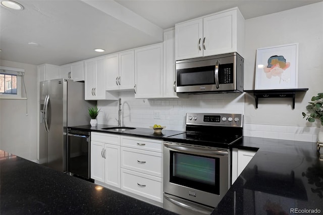 kitchen with tasteful backsplash, sink, white cabinets, and appliances with stainless steel finishes