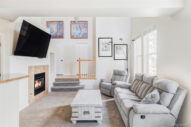 living room featuring a tiled fireplace and light carpet