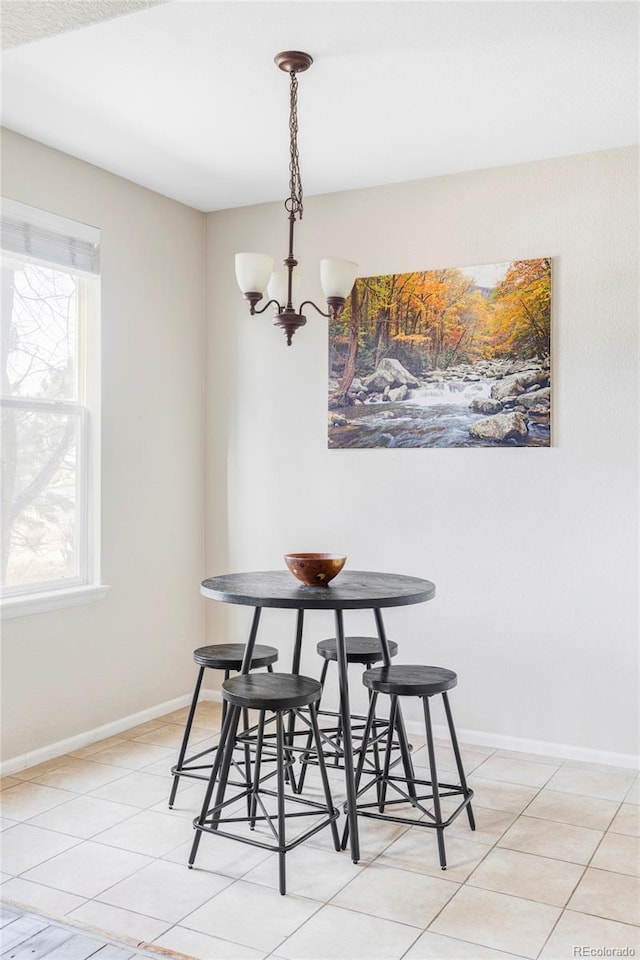 dining area with a chandelier and light tile patterned flooring