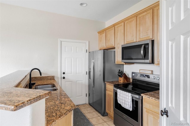 kitchen featuring appliances with stainless steel finishes, light brown cabinetry, and sink