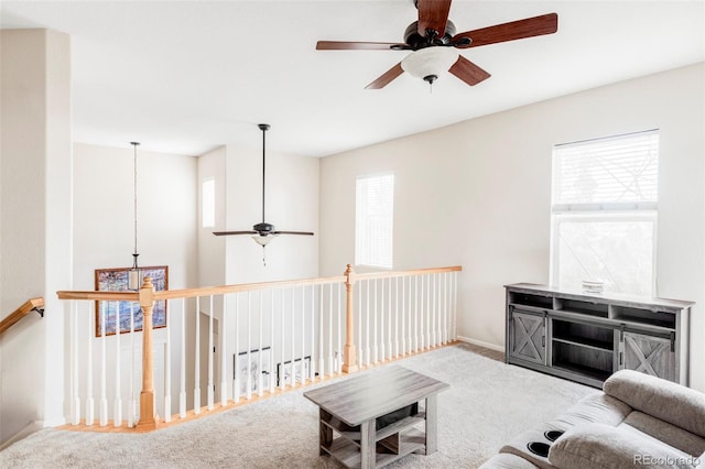 carpeted living room with ceiling fan