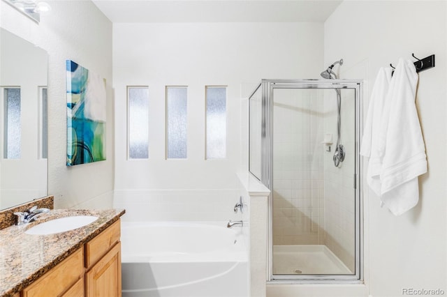 bathroom with vanity and shower with separate bathtub