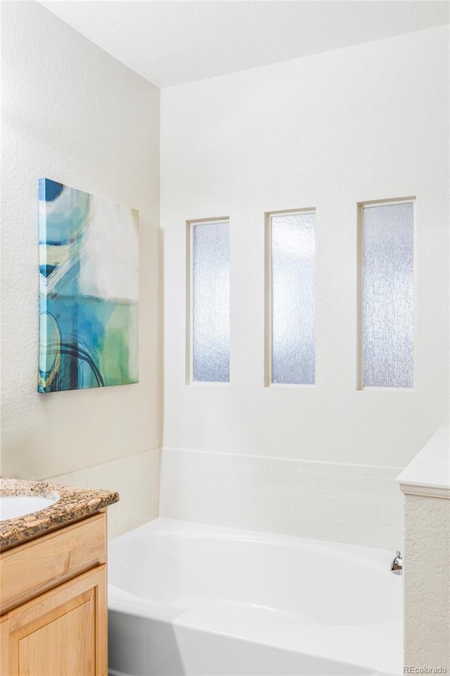 bathroom with a bathing tub and vanity