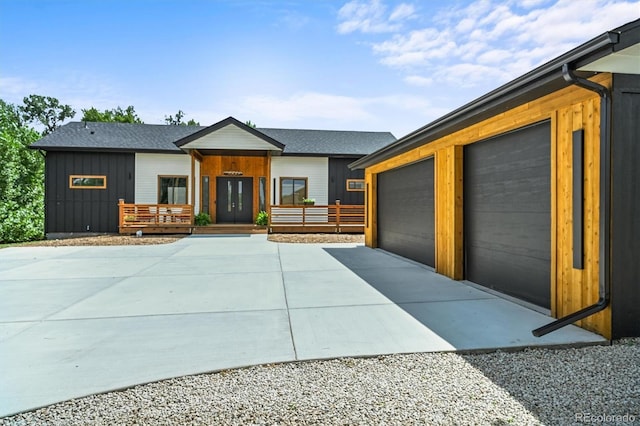 14950 W 32nd Ave, Golden, CO 80401 - view of front of home featuring a garage, driveway, a porch, and board and batten siding