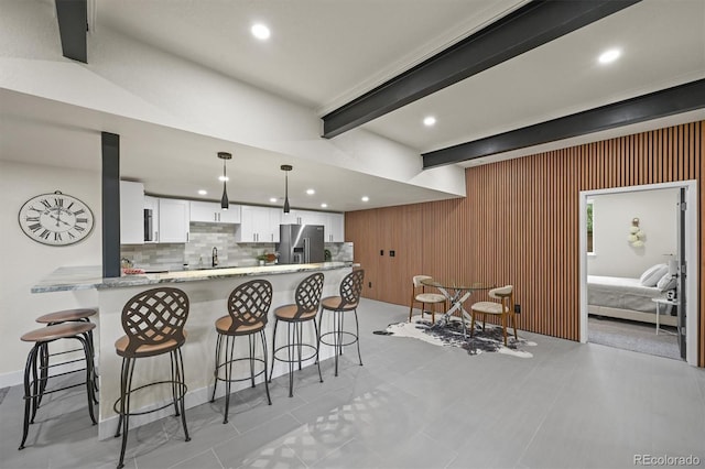 14950 W 32nd Ave, Golden, CO 80401 - kitchen featuring stainless steel refrigerator with ice dispenser, recessed lighting, white cabinets, beam ceiling, and a kitchen breakfast bar