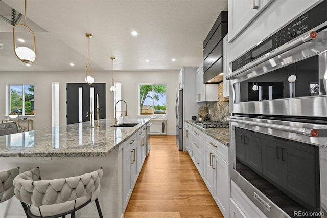 14950 W 32nd Ave, Golden, CO 80401 - kitchen featuring stainless steel appliances, light wood-style flooring, healthy amount of natural light, tasteful backsplash, and recessed lighting