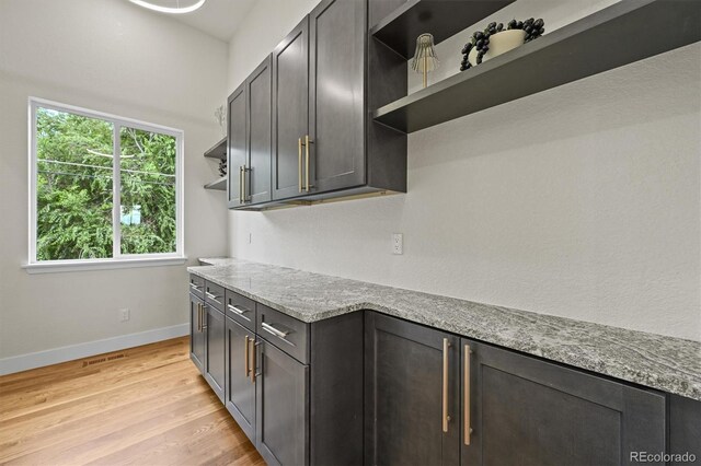 14950 W 32nd Ave, Golden, CO 80401 - kitchen featuring open shelves, light wood-type flooring, and light stone countertops