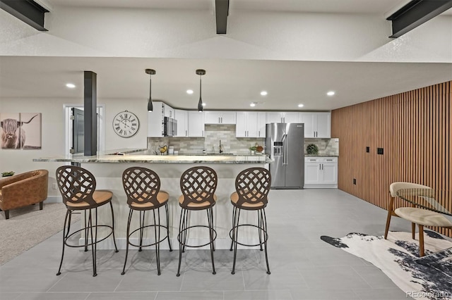14950 W 32nd Ave, Golden, CO 80401 - kitchen with appliances with stainless steel finishes, white cabinets, recessed lighting, decorative backsplash, and a breakfast bar area