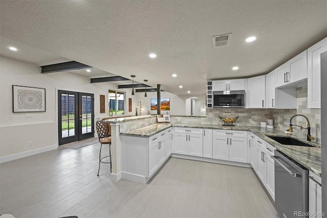 14950 W 32nd Ave, Golden, CO 80401 - kitchen with appliances with stainless steel finishes, a peninsula, tasteful backsplash, white cabinets, and light stone countertops