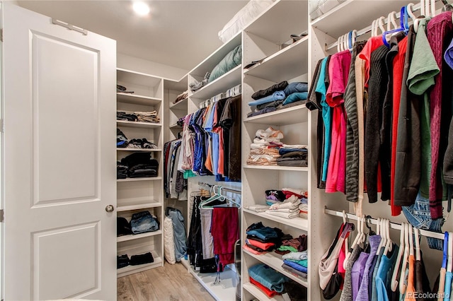 walk in closet with light hardwood / wood-style flooring