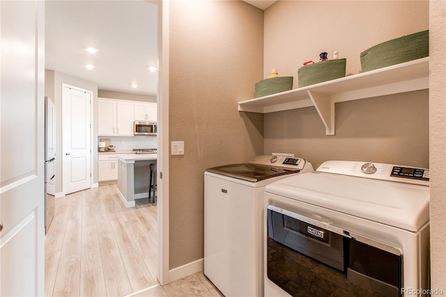 washroom featuring light hardwood / wood-style floors and washing machine and dryer