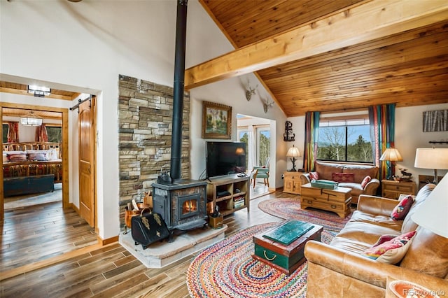 34 Nebraska Cir, Florissant, CO 80816 - living room with wood finished floors, a wood stove, beam ceiling, baseboards, and wood ceiling