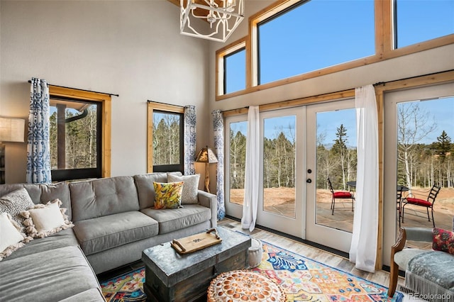 34 Nebraska Cir, Florissant, CO 80816 - living area featuring a high ceiling, french doors, an inviting chandelier, and light wood-style flooring