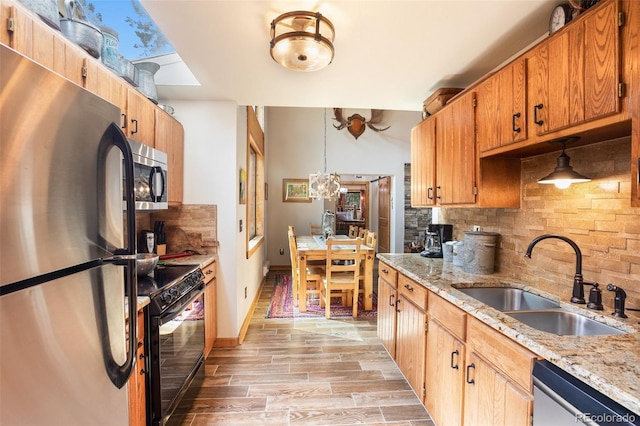 34 Nebraska Cir, Florissant, CO 80816 - kitchen featuring a sink, stainless steel appliances, light wood finished floors, backsplash, and light stone countertops