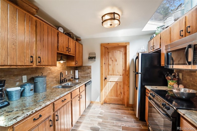 34 Nebraska Cir, Florissant, CO 80816 - kitchen featuring decorative backsplash, stainless steel appliances, a sink, and light wood-style flooring