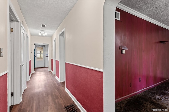 corridor with wood-type flooring and a textured ceiling