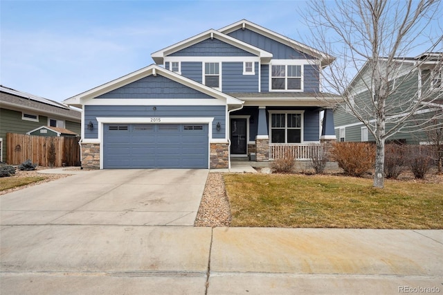 craftsman-style house featuring covered porch, a garage, fence, driveway, and board and batten siding