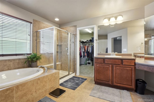 full bath with a stall shower, a spacious closet, vanity, and a bath