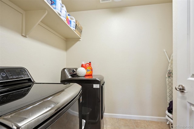 laundry room with laundry area, light tile patterned floors, visible vents, baseboards, and washer and dryer