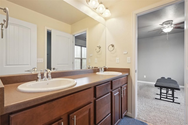 full bathroom with double vanity, a sink, a ceiling fan, and baseboards