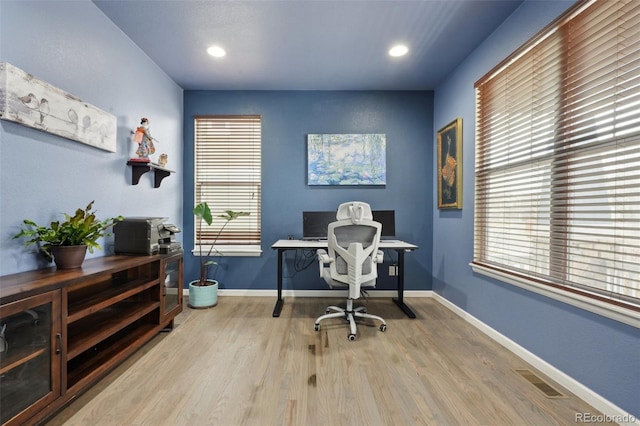 office area featuring light wood-type flooring, a healthy amount of sunlight, and baseboards