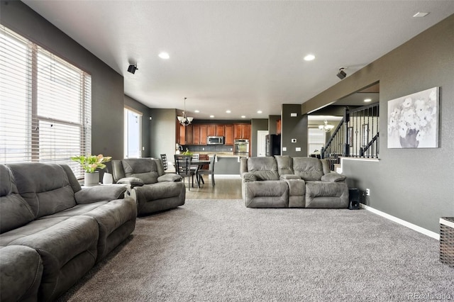 living area featuring baseboards, stairway, recessed lighting, and an inviting chandelier