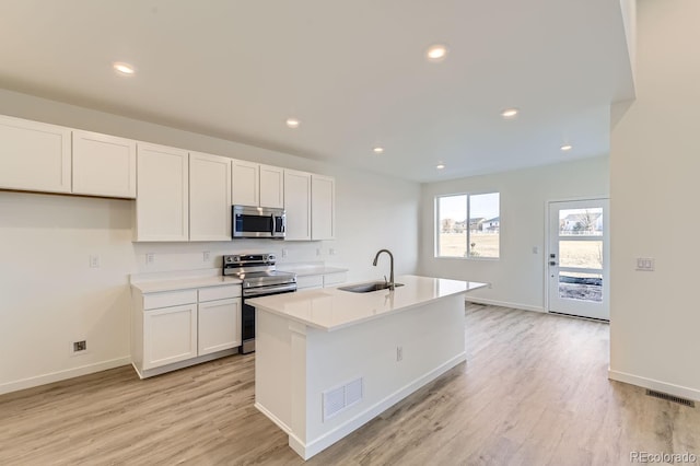 kitchen featuring white cabinetry, sink, an island with sink, and appliances with stainless steel finishes